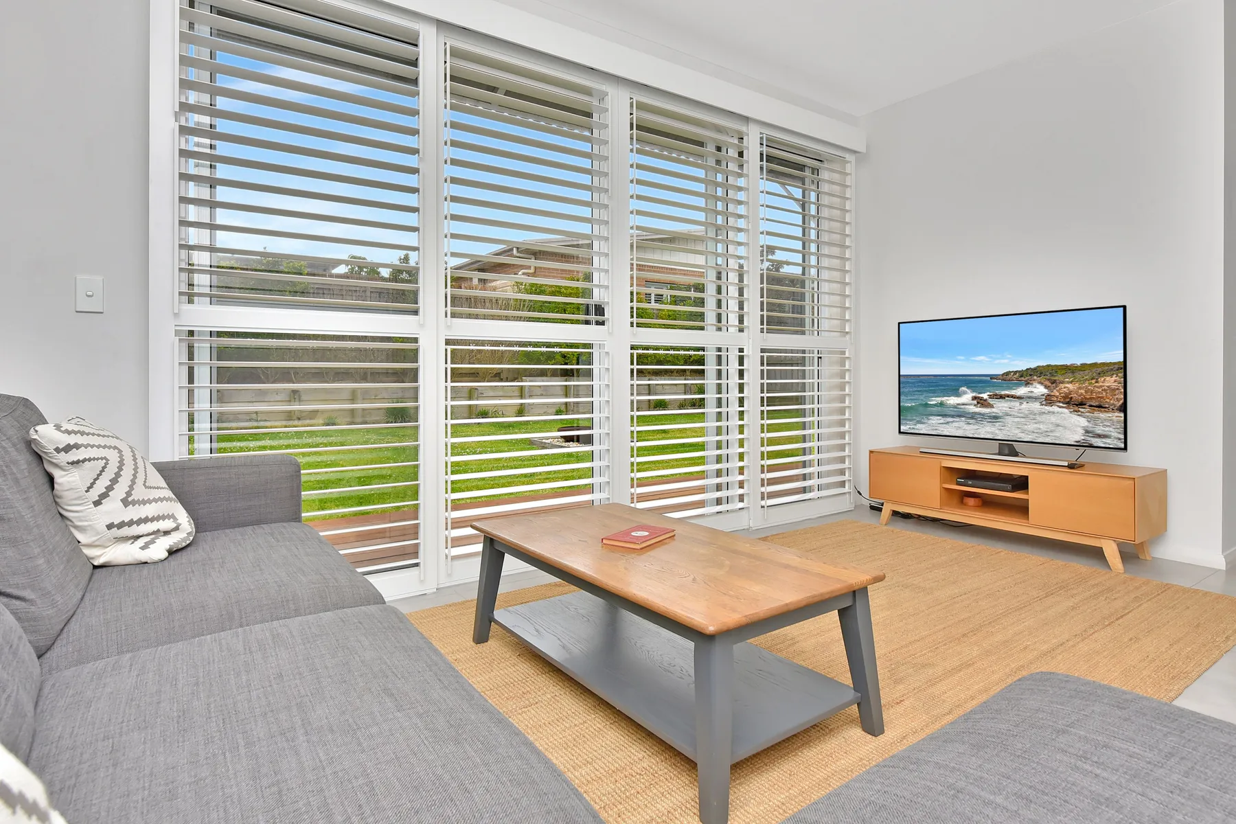 Living room with seating, a coffee table, and large windows.