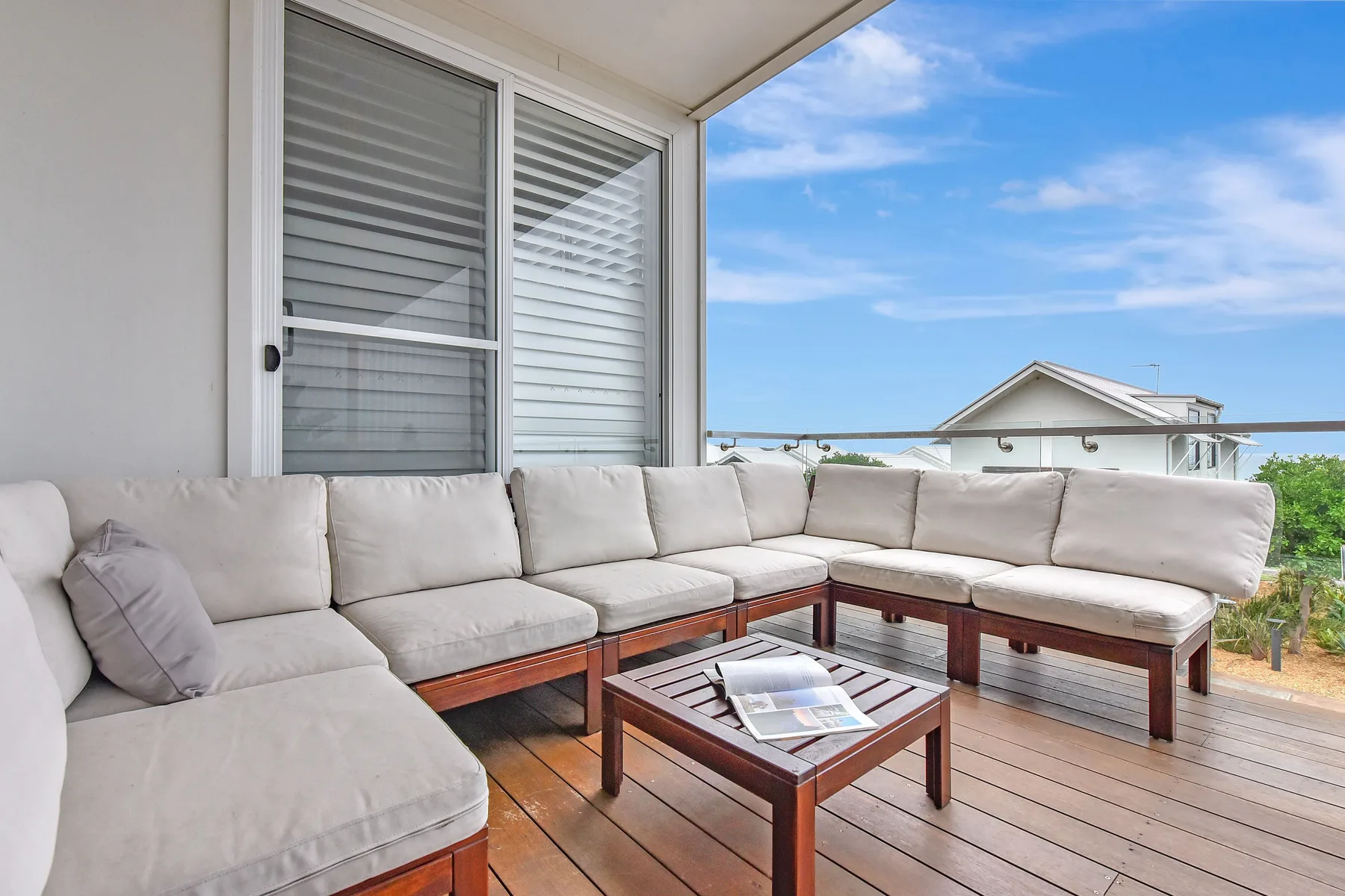 An outdoor seating area with a low table and views of nearby houses.