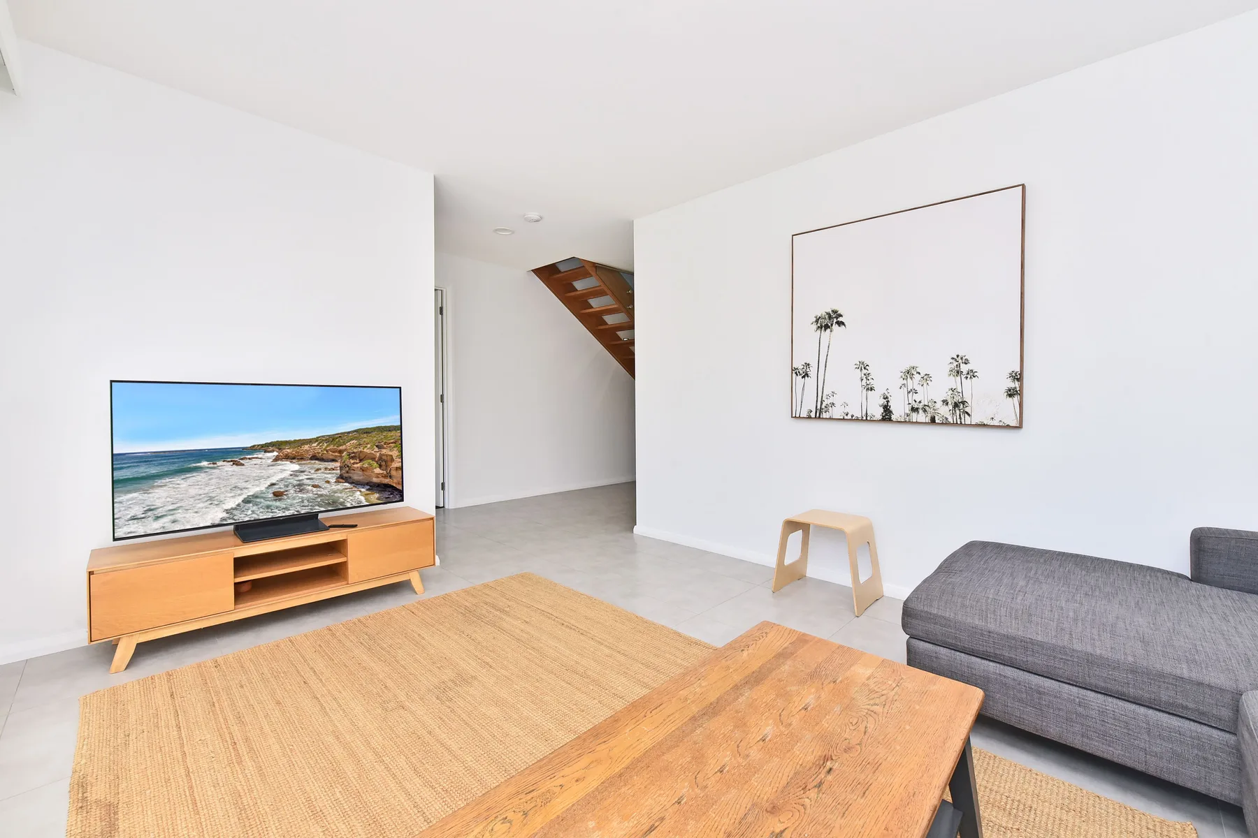 A living room with seating, a television, and a wooden coffee table.
