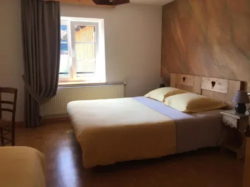 Habitación luminosa con cama de madera y suelo de parquet.