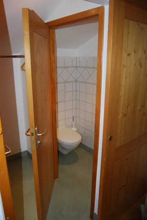 Baño compacto alicatado con inodoro.