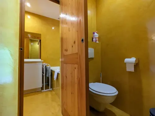Baño con vigas de madera, lavabo y toallero.
