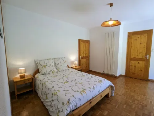 Habitación con cama de madera, vistas al jardín y suelo de parquet.