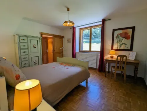 Habitación con vistas al jardín, escritorio e iluminación cálida.