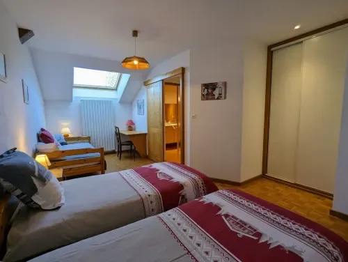 Habitación Chardon con dos camas individuales y muebles de madera.