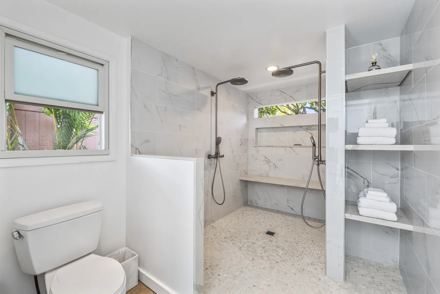 Un baño luminoso con ducha a ras de suelo y paredes de azulejos.