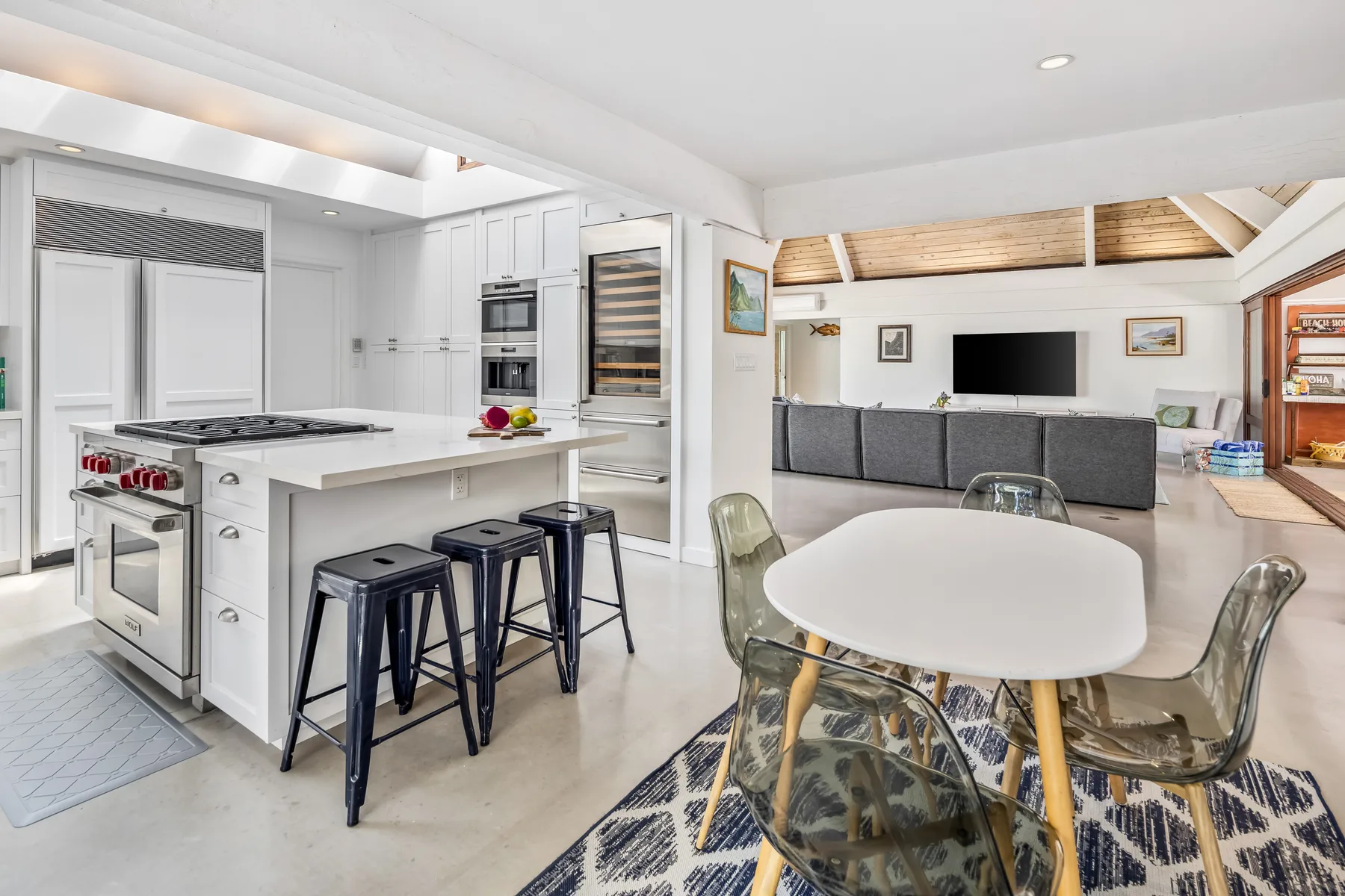 Una luminosa cocina y comedor de concepto abierto con isla y mesa.