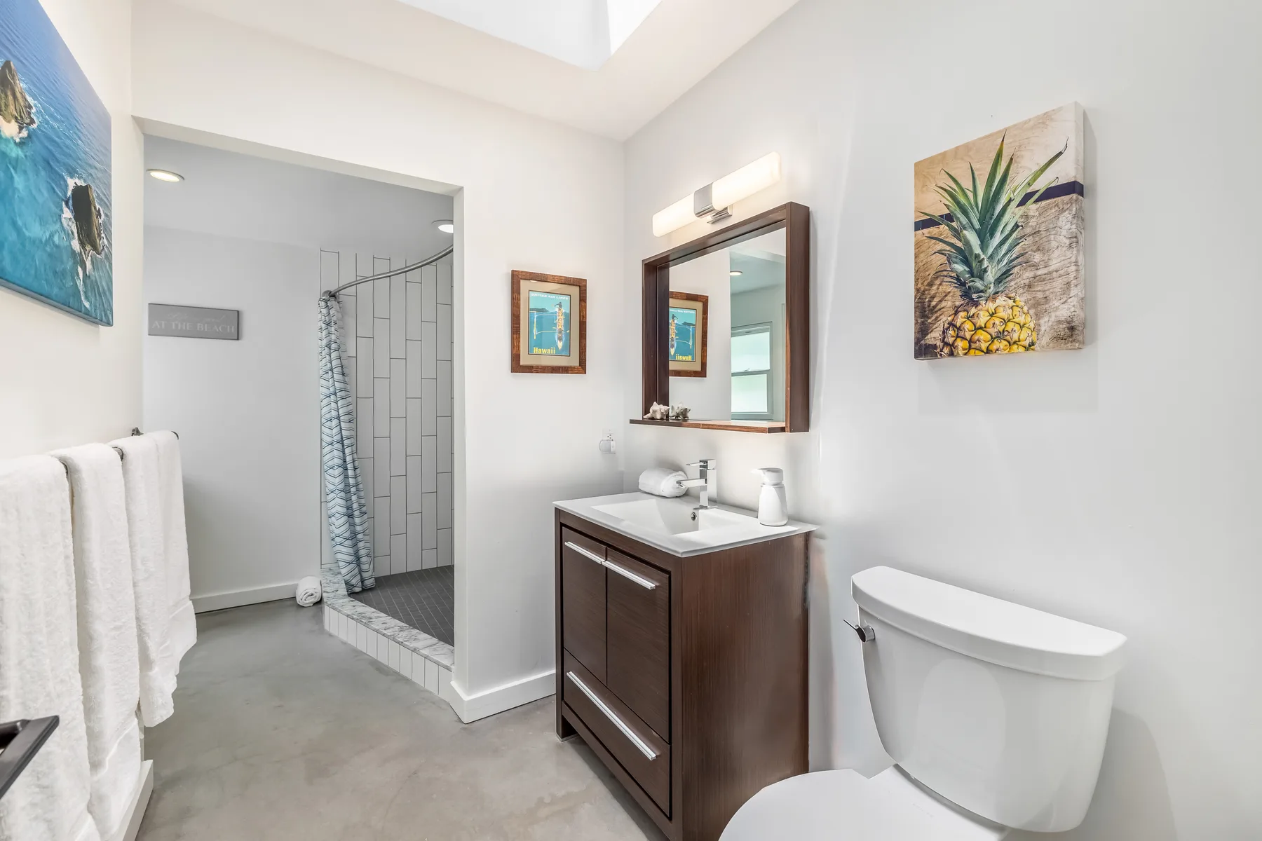 Un baño luminoso con lavabo, inodoro y ducha con azulejos.