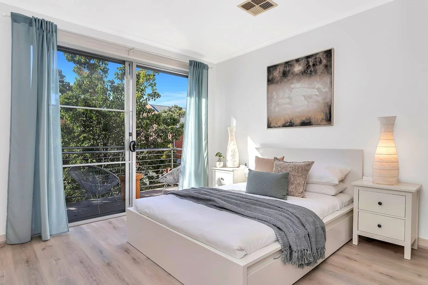 Un dormitorio con una cama junto a puertas corredizas de vidrio que dan a un balcón.