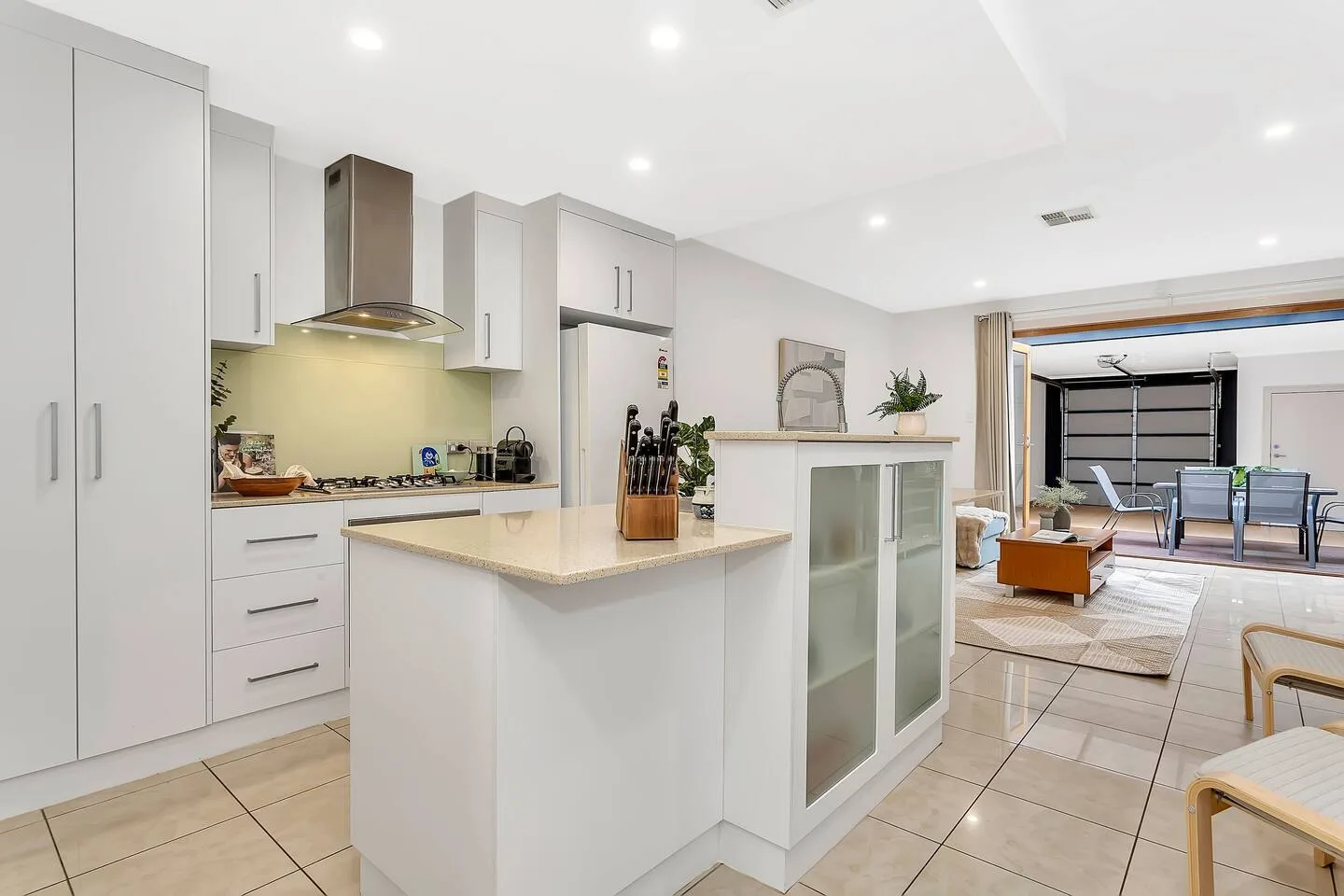 Una cocina luminosa con isla central se abre a una zona de comedor y estar.
