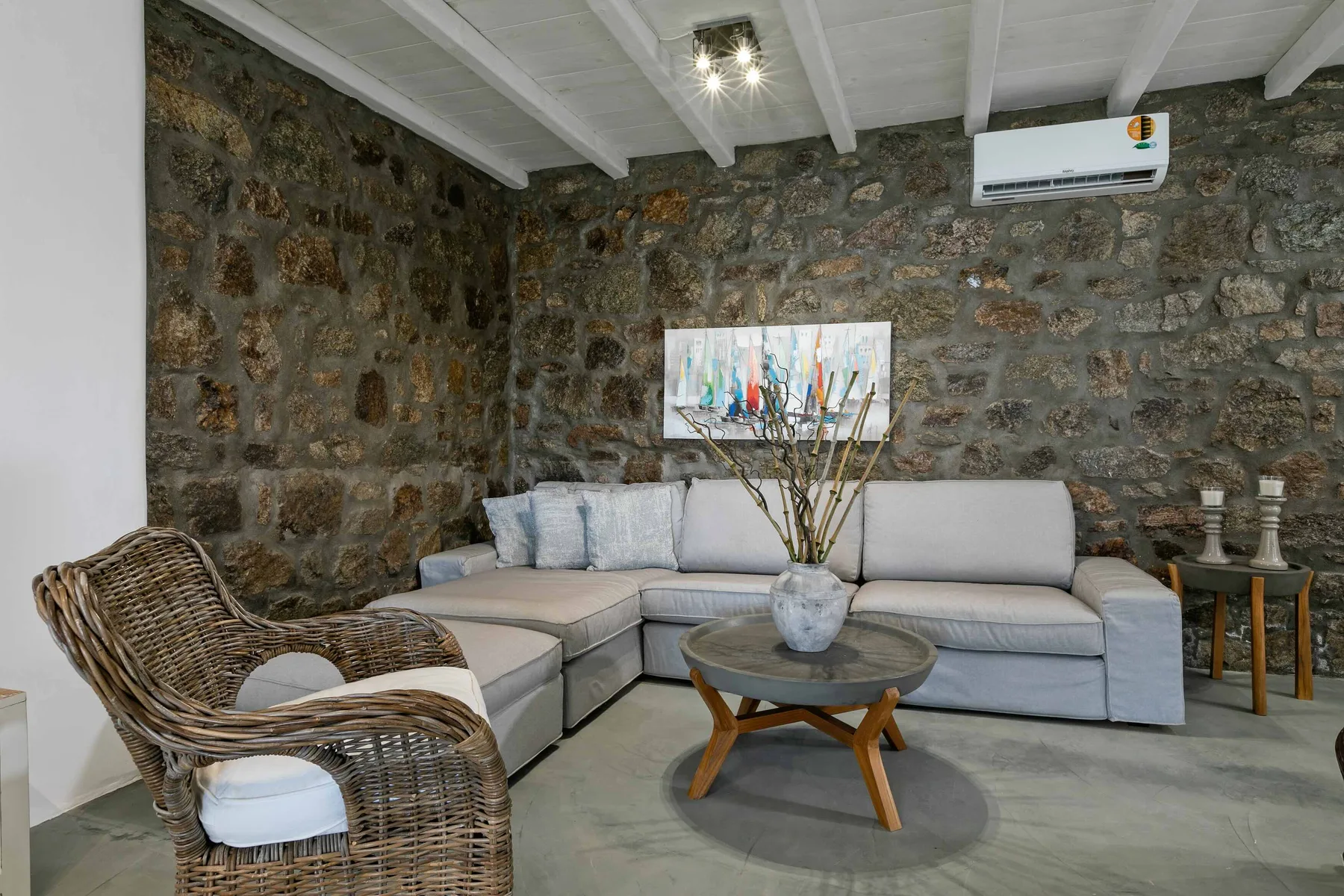 Una sala de estar con asientos seccionales y un sillón tejido.