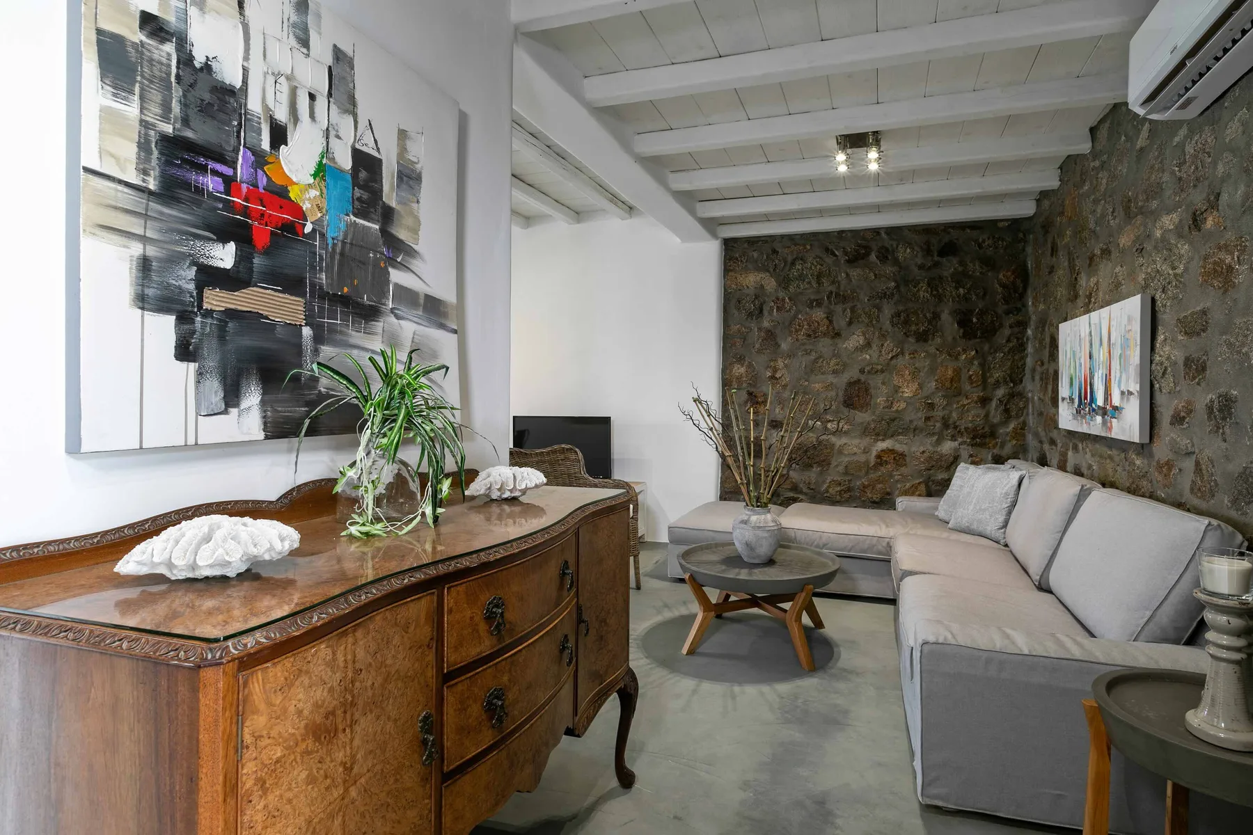 Una sala de estar con asientos, una mesa de centro y obras de arte en las paredes.