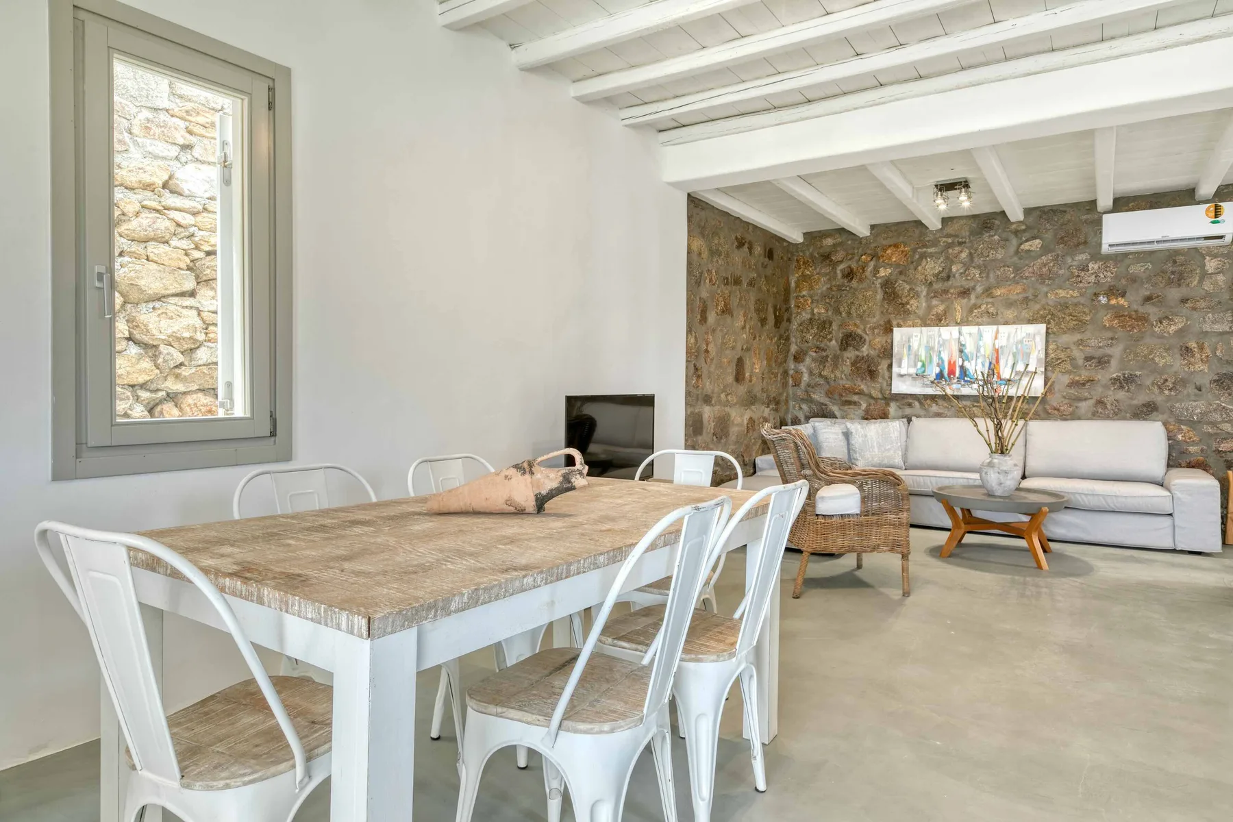 Un comedor con mesa y asientos junto a una zona de estar.