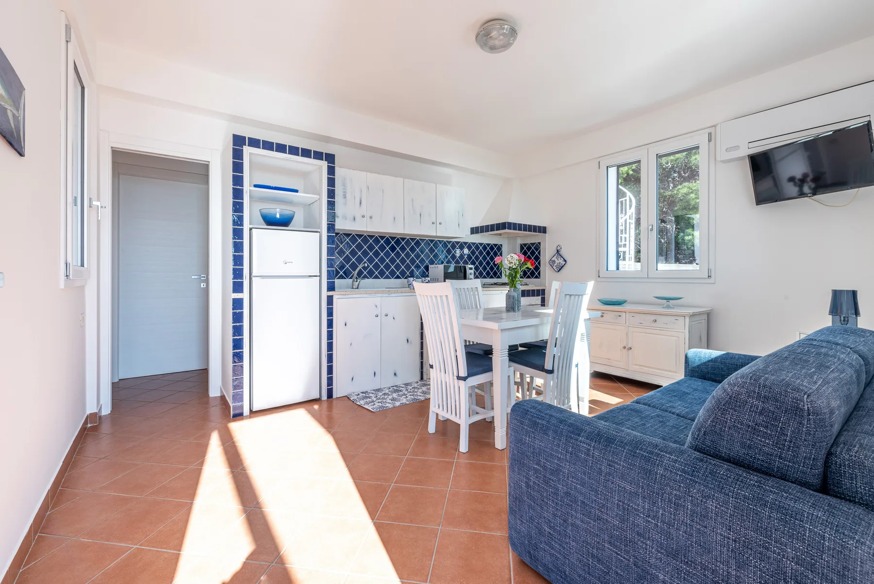 Una cocina y comedor luminosos con una mesa junto a las ventanas.