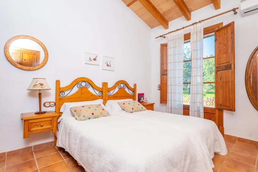 Un dormitorio con una cama doble bajo un techo con vigas de madera.