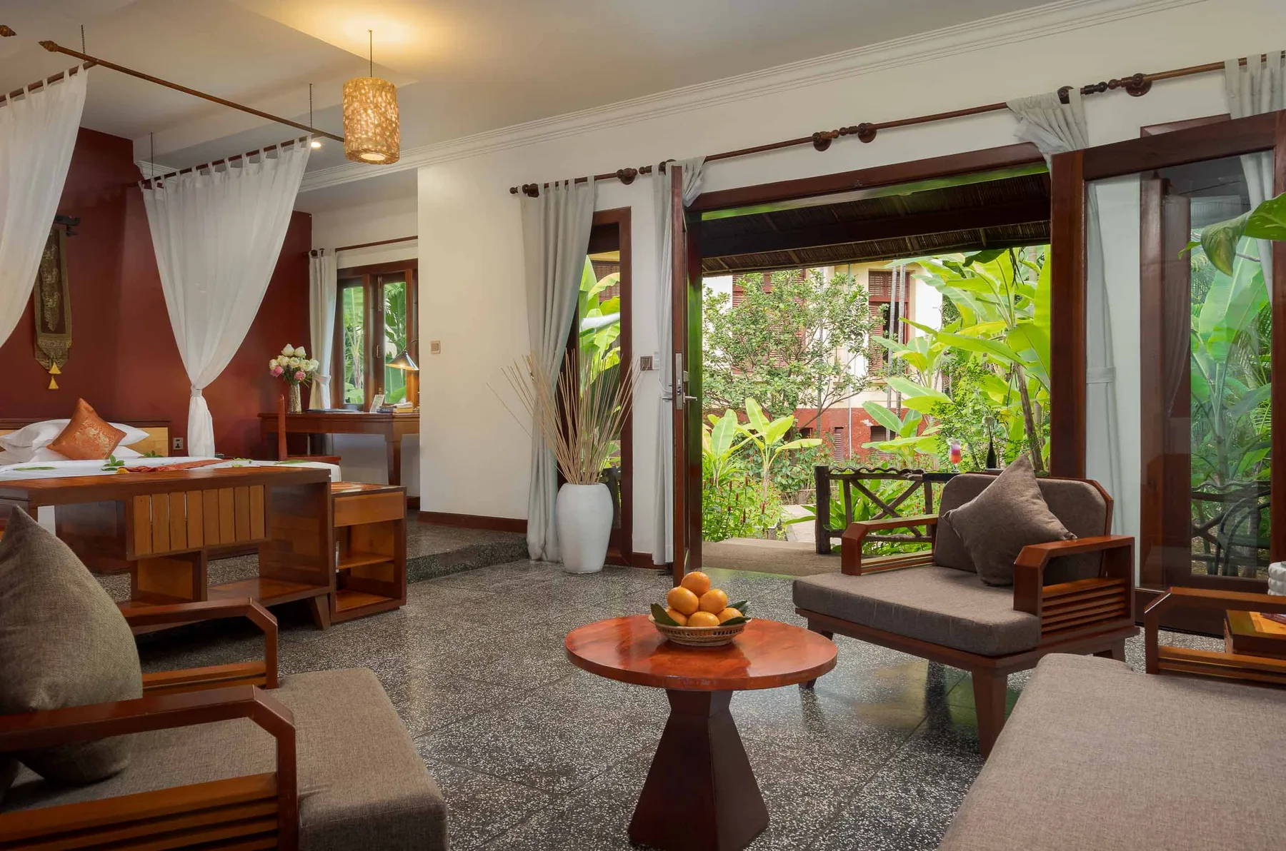 Suite de hotel con dos camas individuales y vistas al jardín