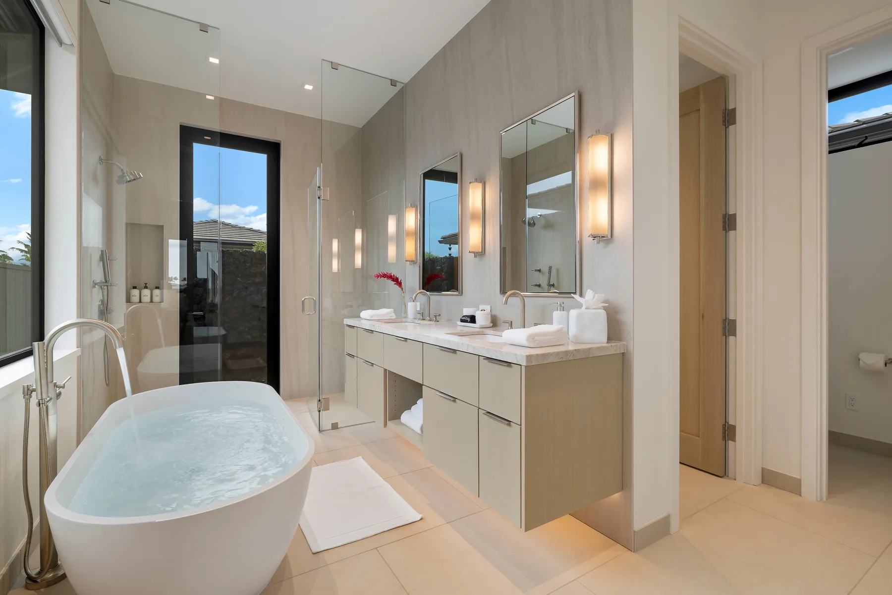 Un baño luminoso con bañera, ducha de vidrio y lavabo.