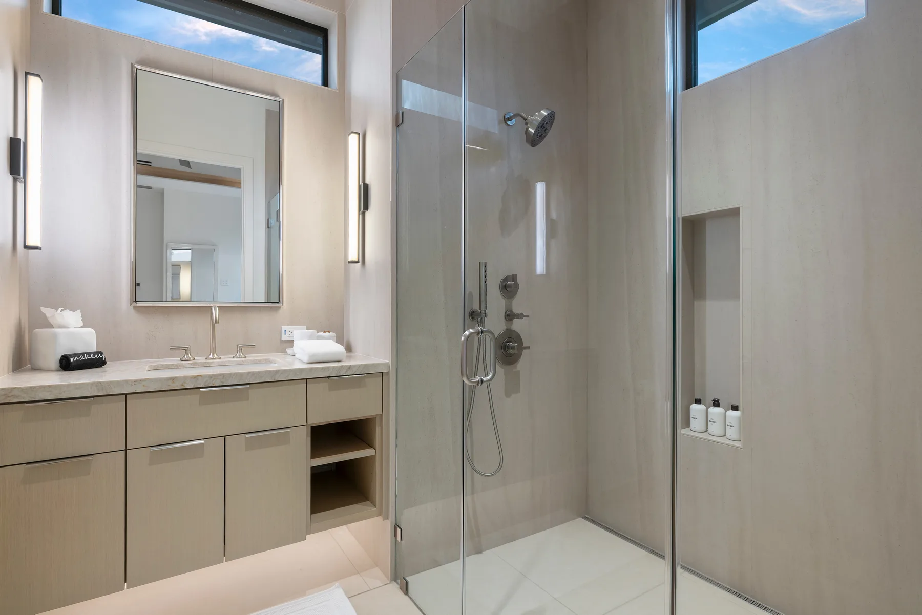 Un baño luminoso con lavabo y ducha de mampara de vidrio.