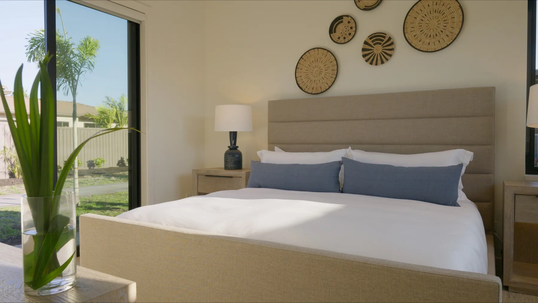 Un dormitorio con una cama bien tendida y adornos tejidos en la pared.