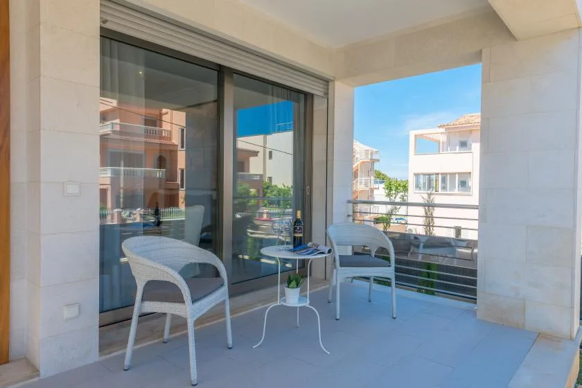 A balcony seating area with a small table beside sliding glass doors.