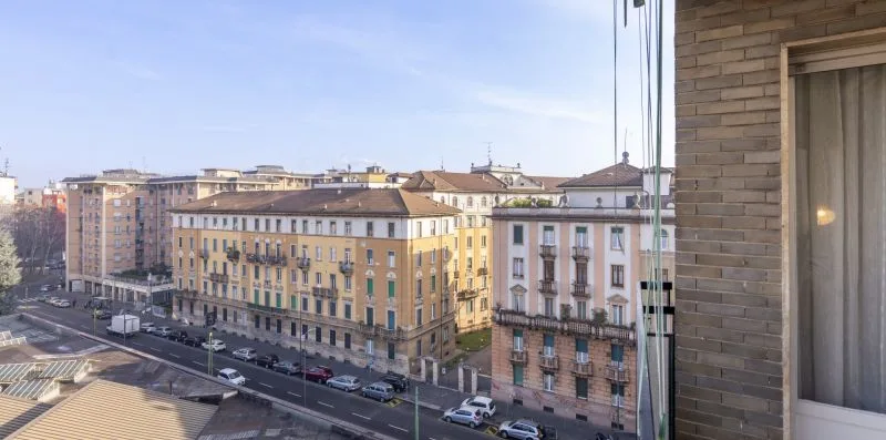 Se ven edificios de la ciudad y una calle a través de una ventana.
