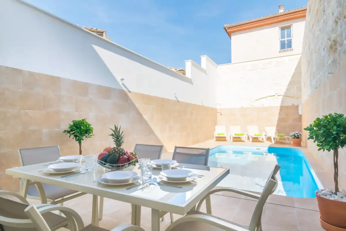 Una zona de comedor en el patio da a una pequeña piscina al aire libre.