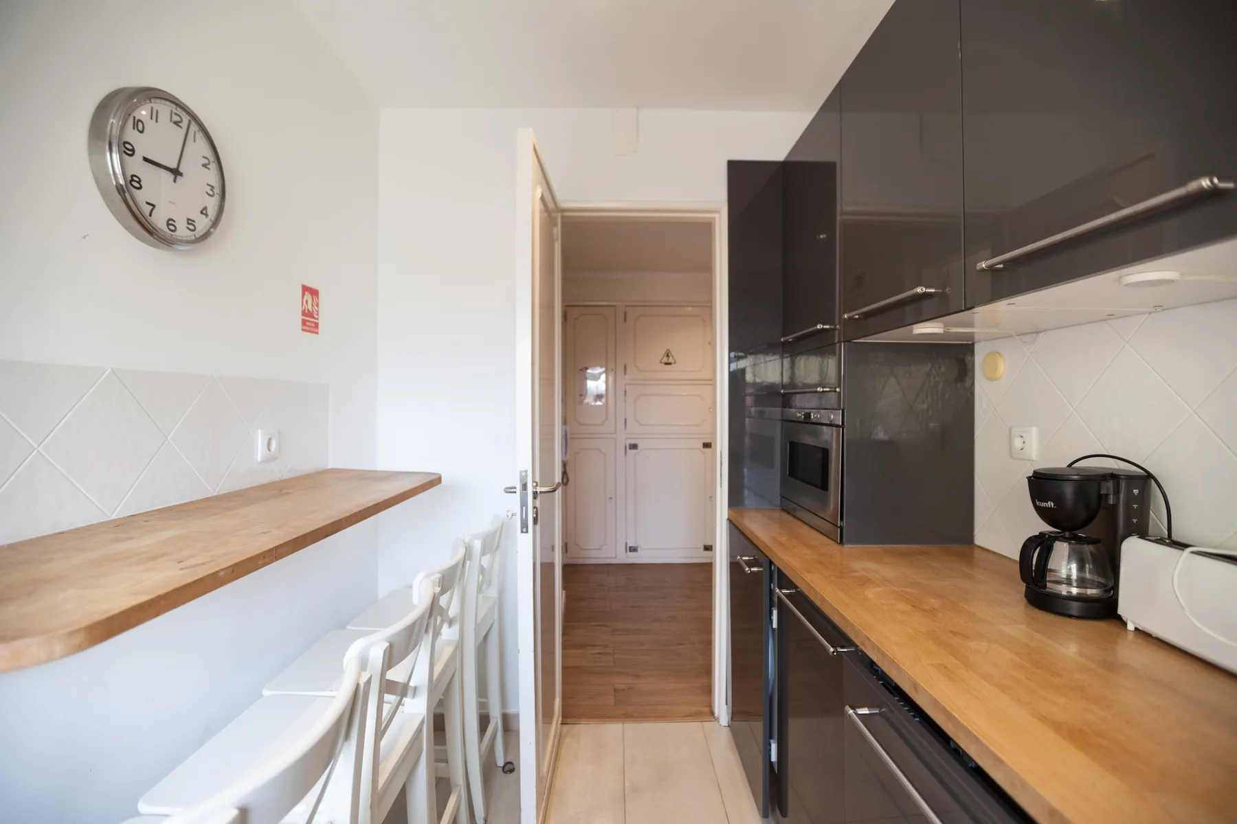 Una cocina moderna con armarios oscuros, encimeras de madera y una barra para desayunar.