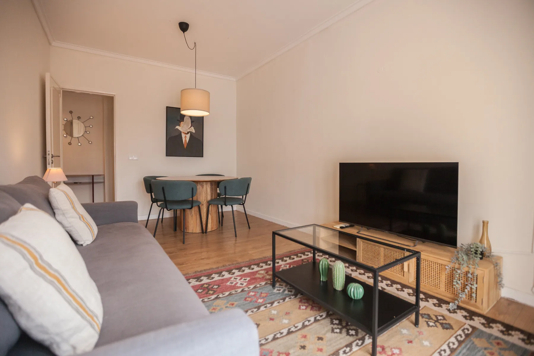 Un salón con mesa de comedor, asientos y un televisor.