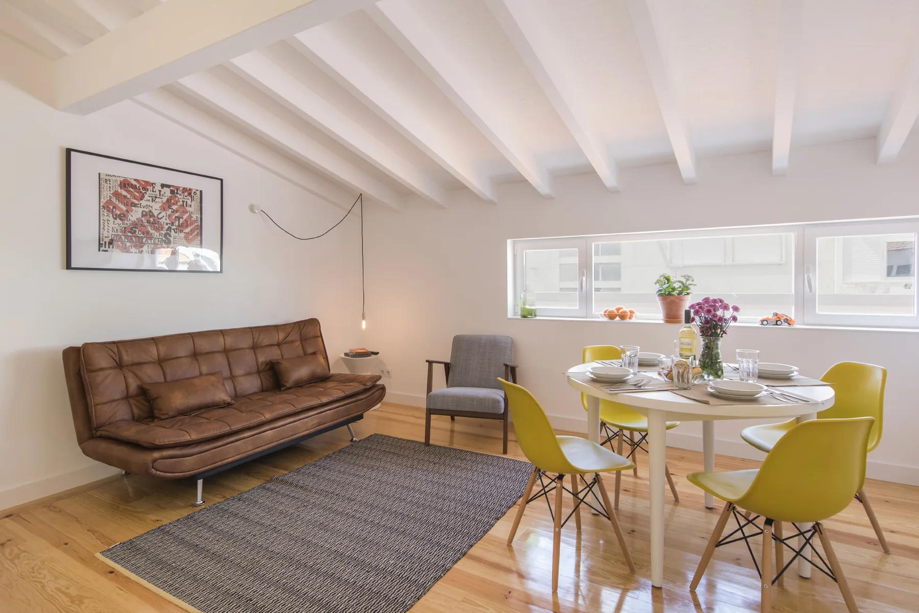 Una luminosa sala de estar y comedor con asientos, una mesa y una ventana amplia.