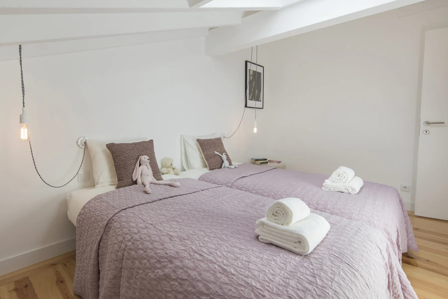 Un dormitorio con una cama grande, toallas dobladas y arte enmarcado en la pared.