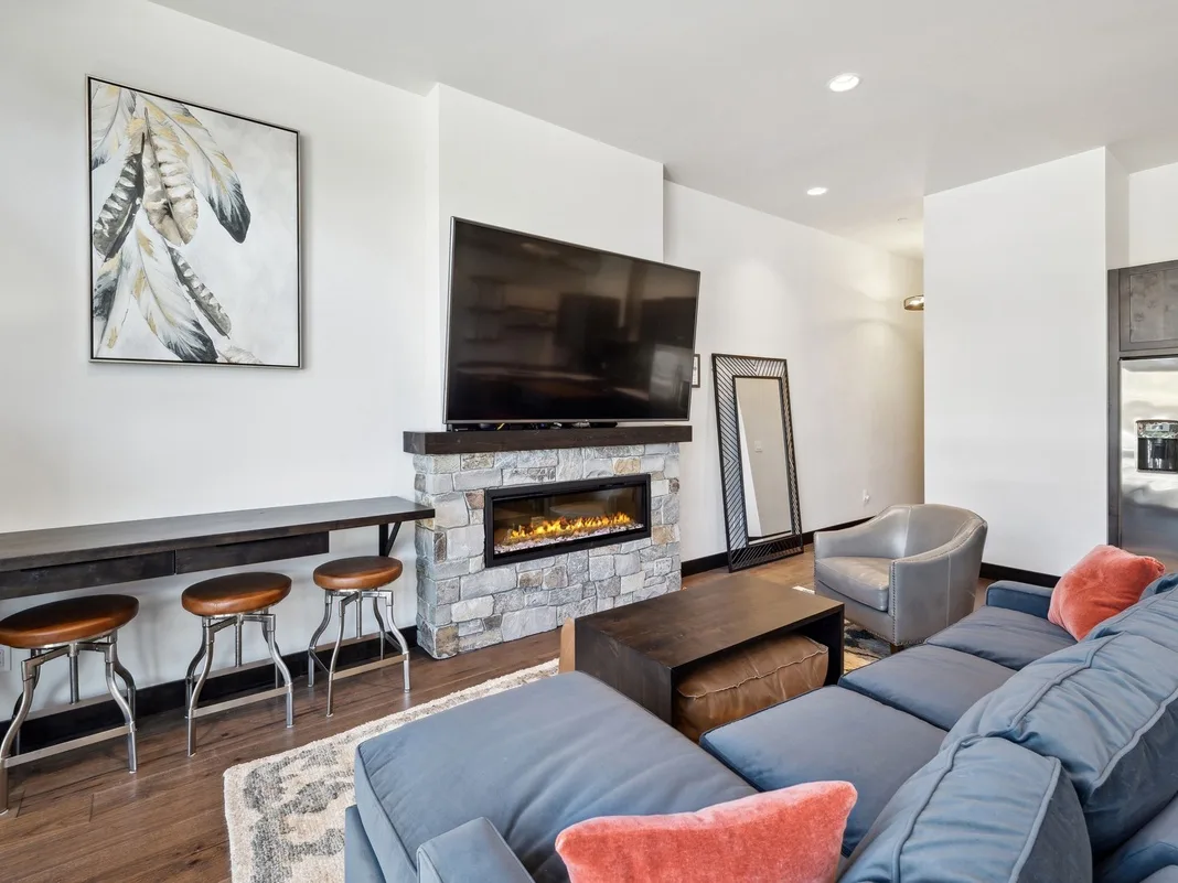 A living room with a stone fireplace, television, and seating.