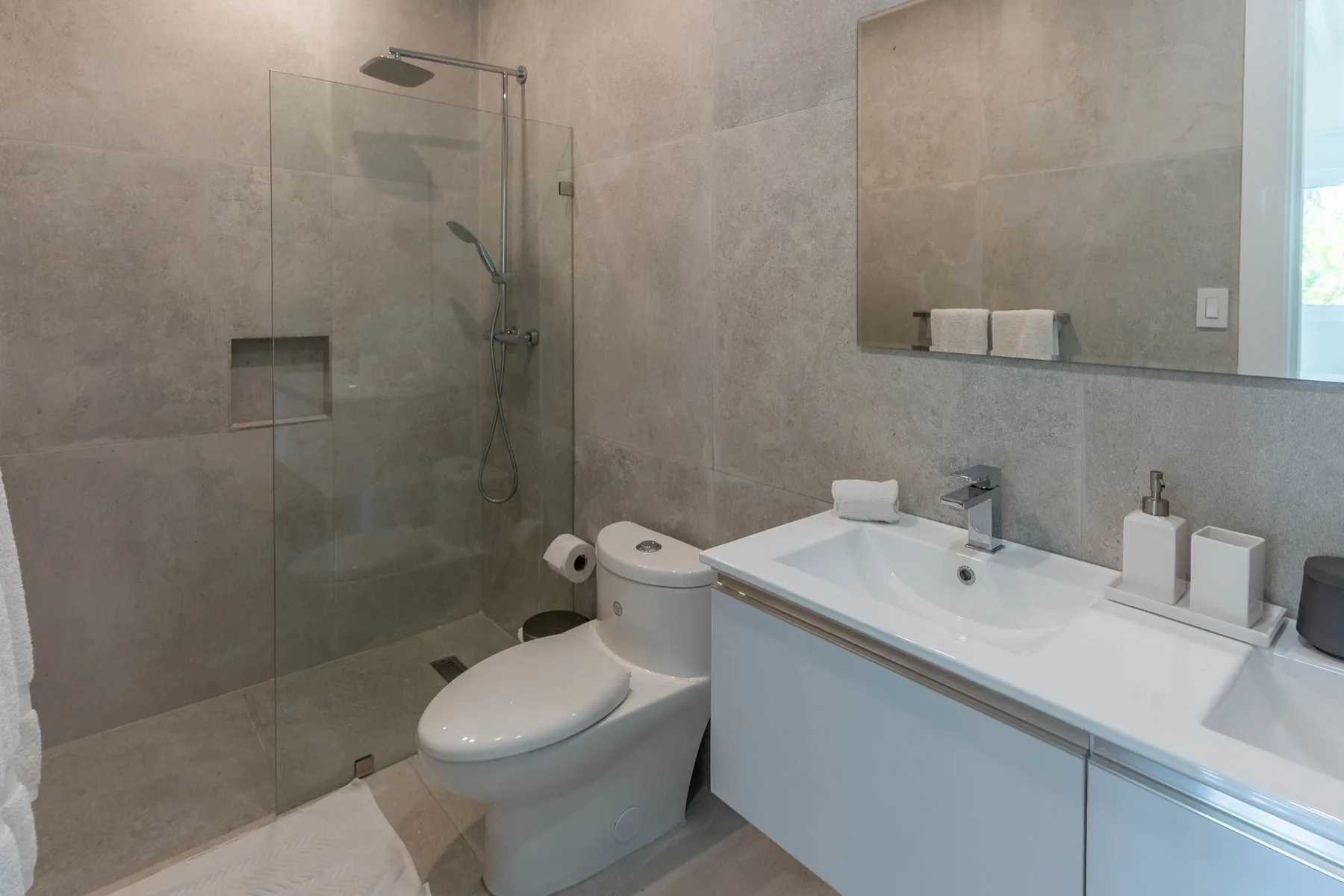 Un baño moderno con ducha, inodoro y lavabo.