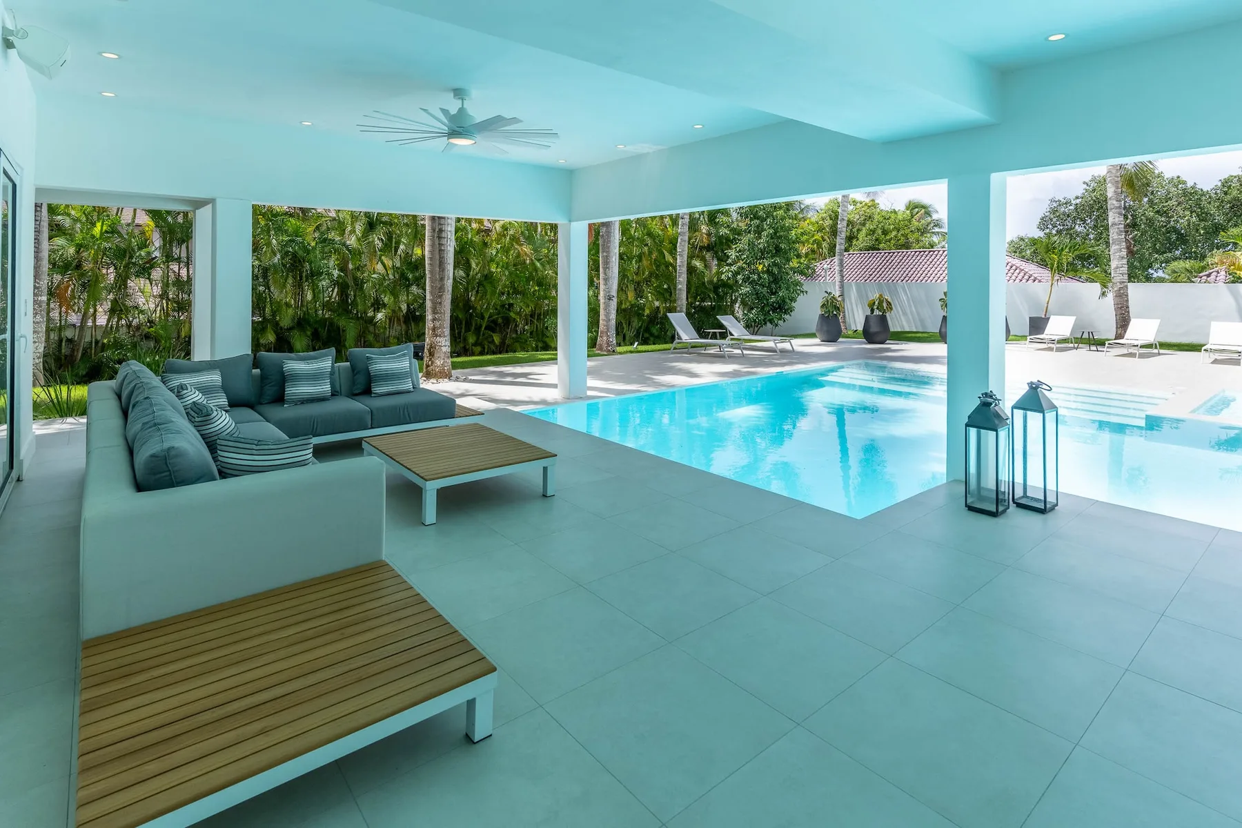 Una zona cubierta para sentarse junto a la piscina, con vistas al jardín.