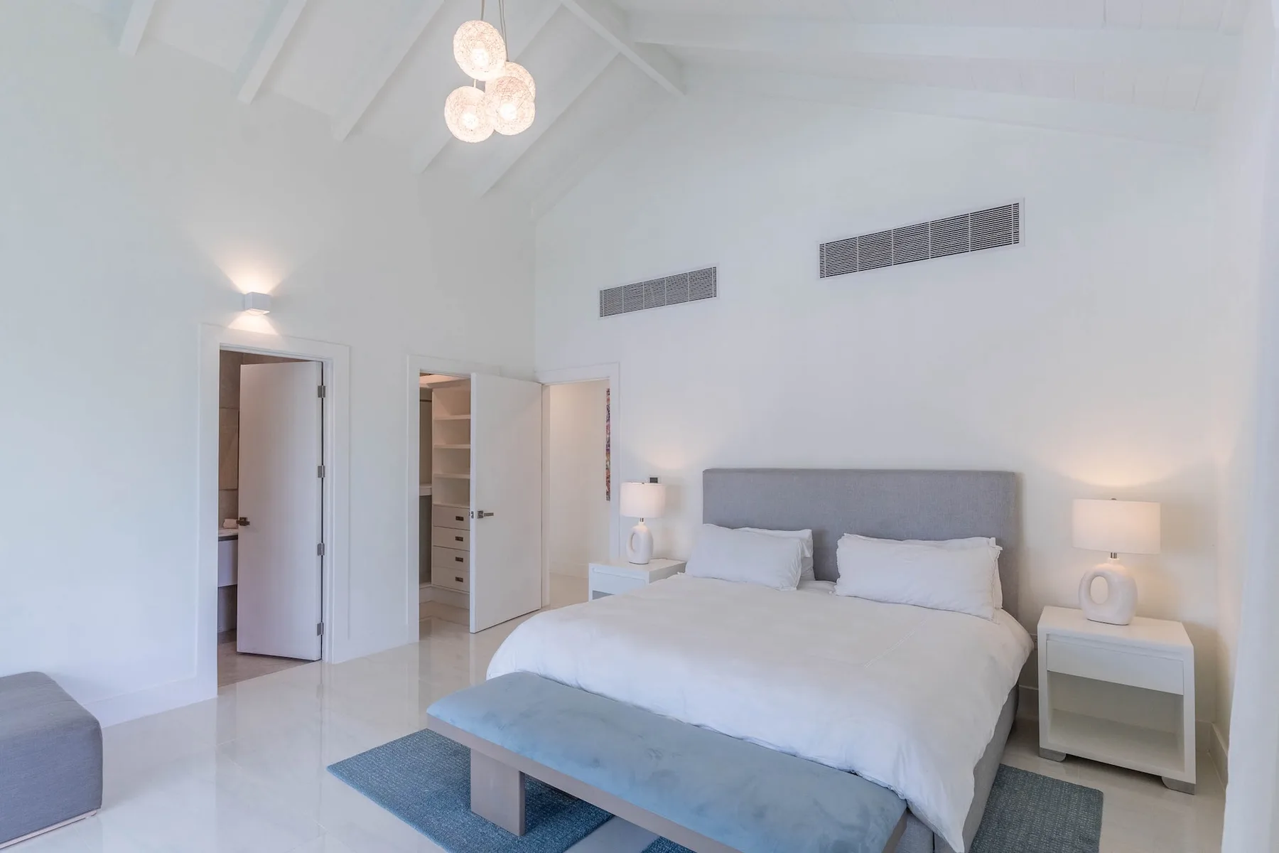 Un dormitorio luminoso cuenta con una cama bien tendida y mesitas de noche a juego.
