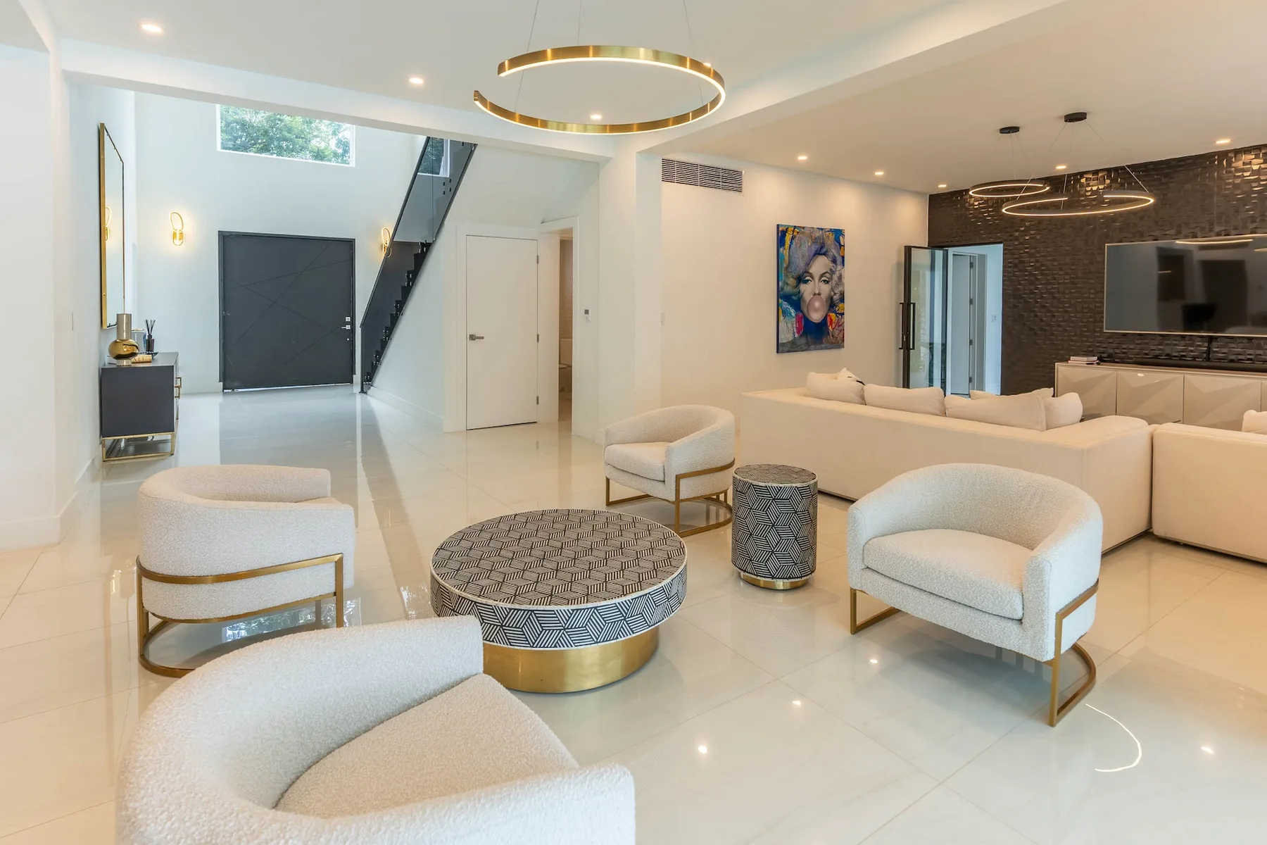 A bright modern living room with pale seating and a round coffee table.