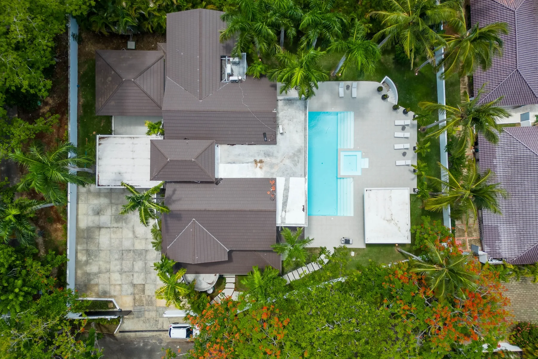 Vista aérea de una propiedad tropical con una piscina junto a varios edificios.