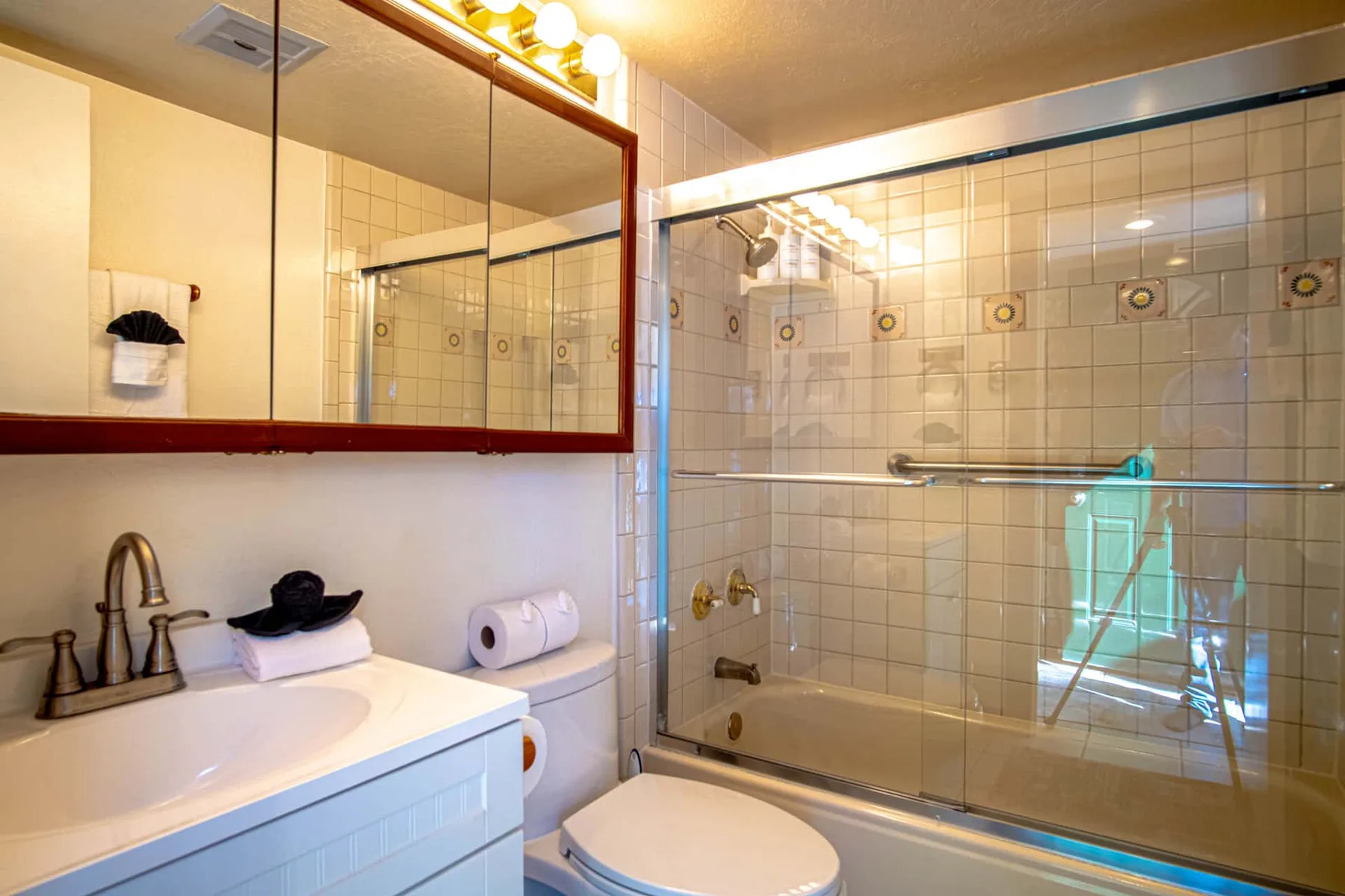 Un baño con lavabo, inodoro y ducha con mampara de vidrio.