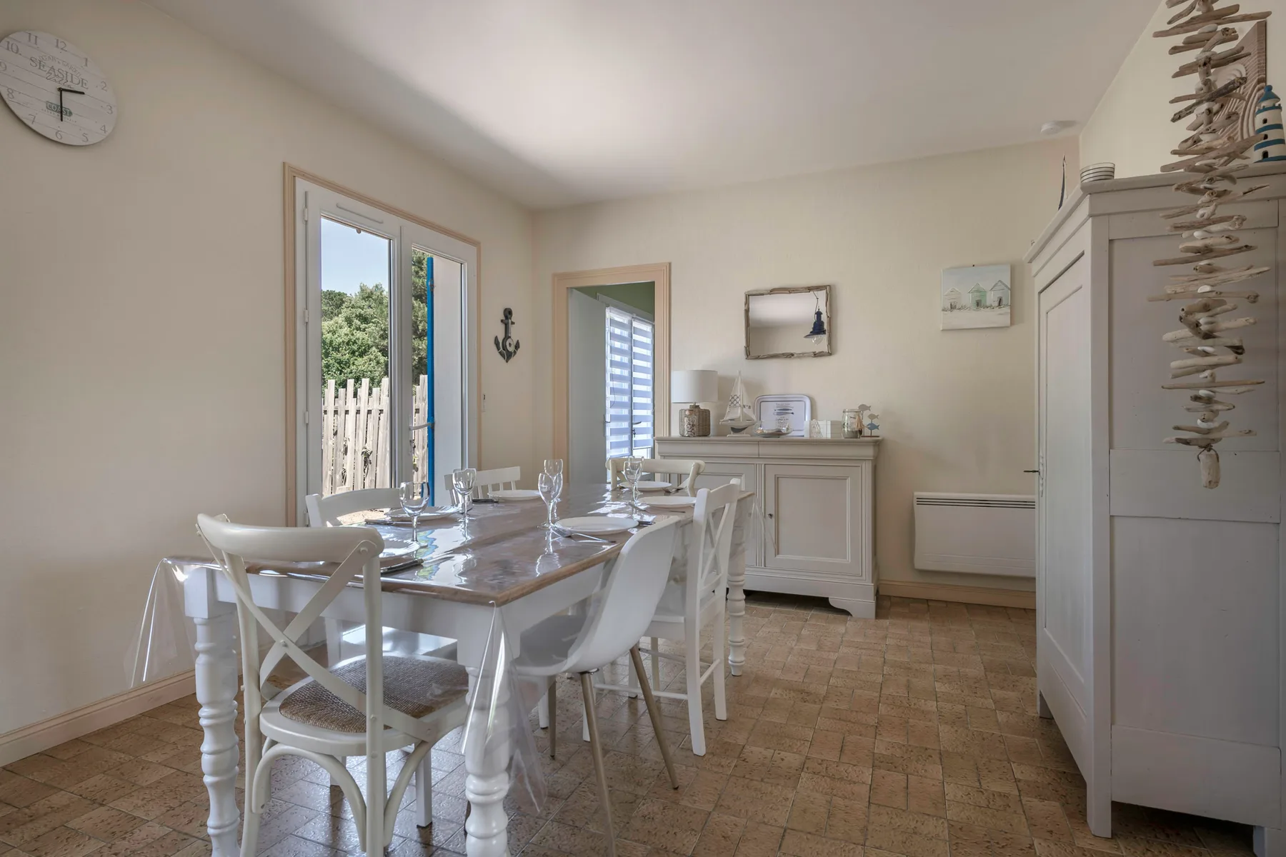 A bright dining room with a table and white seating.