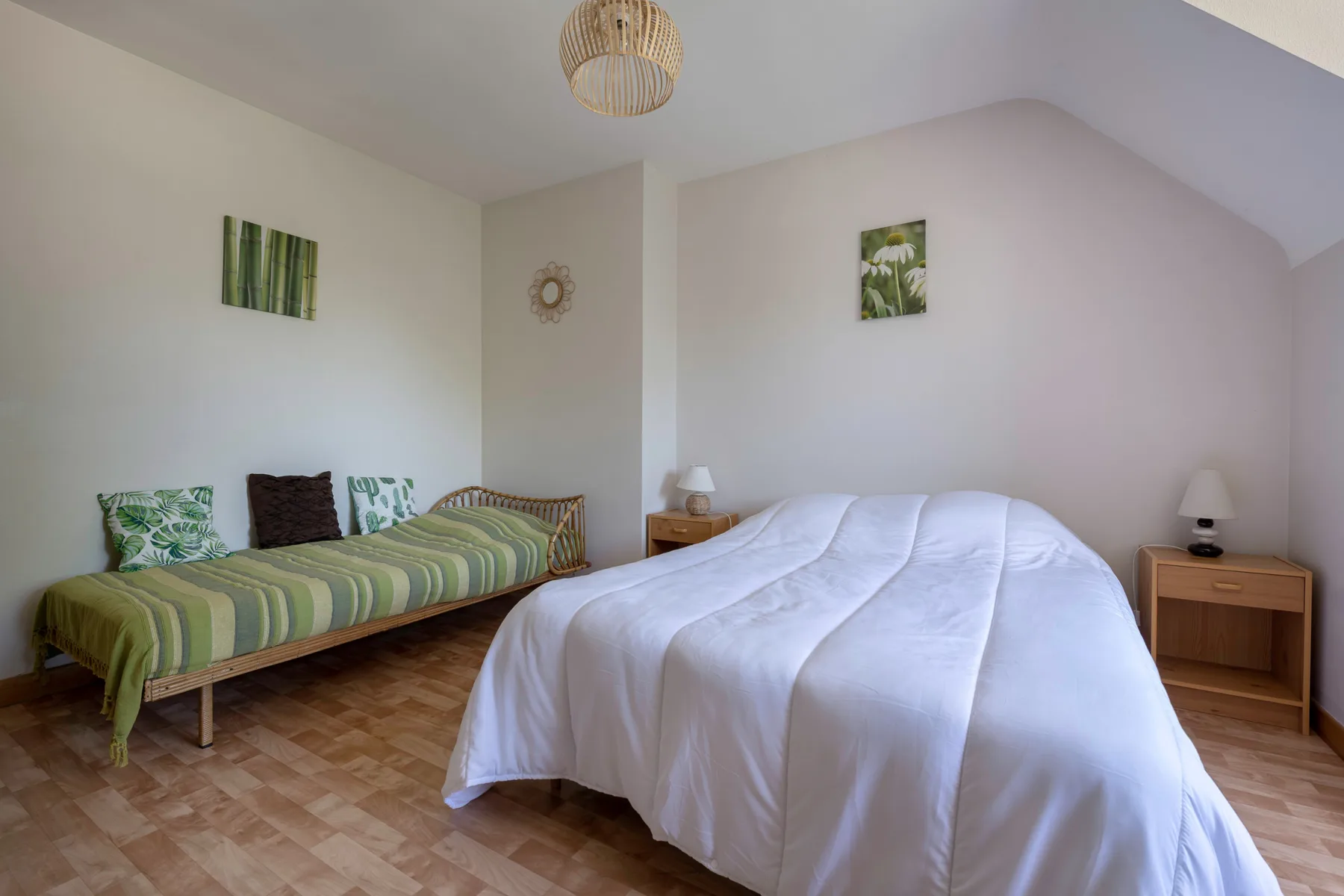 A bedroom with two beds, including one covered in white bedding.