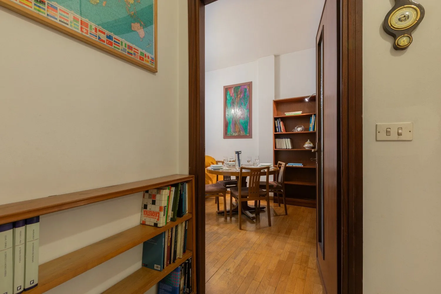 A doorway opens onto a dining area with a wooden table and chairs.