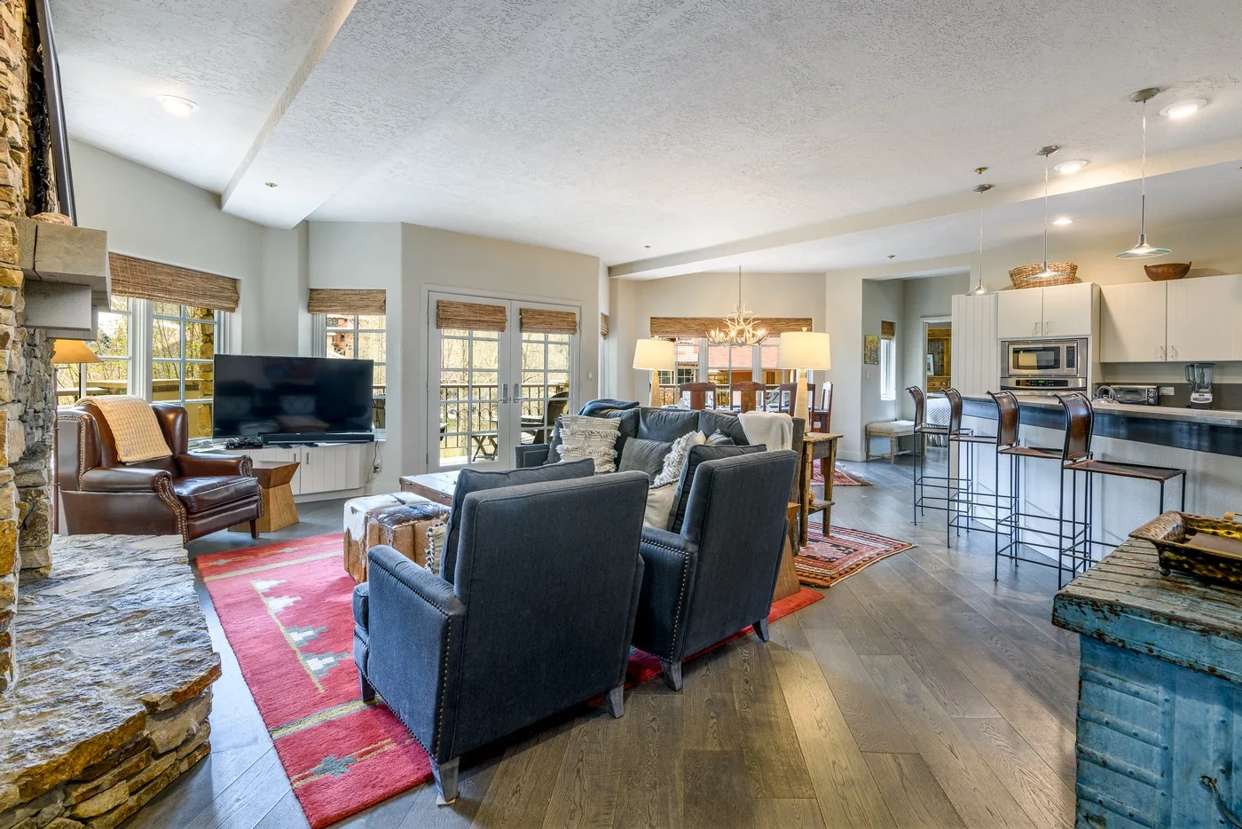 An open-plan living and kitchen area with seating, a television, and a dining counter.