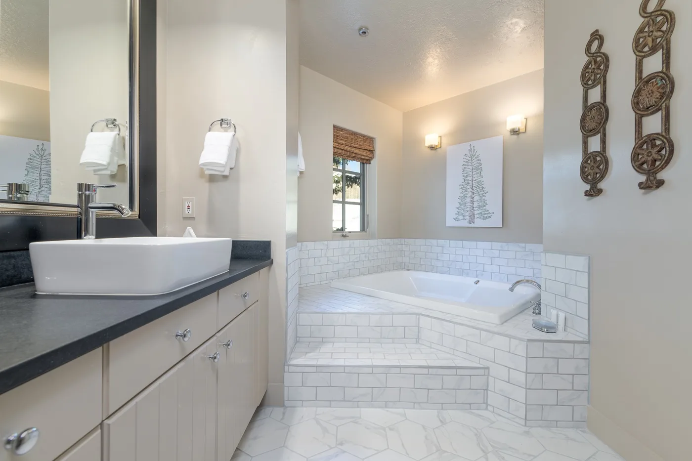 A bright bathroom features a built-in tub and a vanity with a vessel sink.