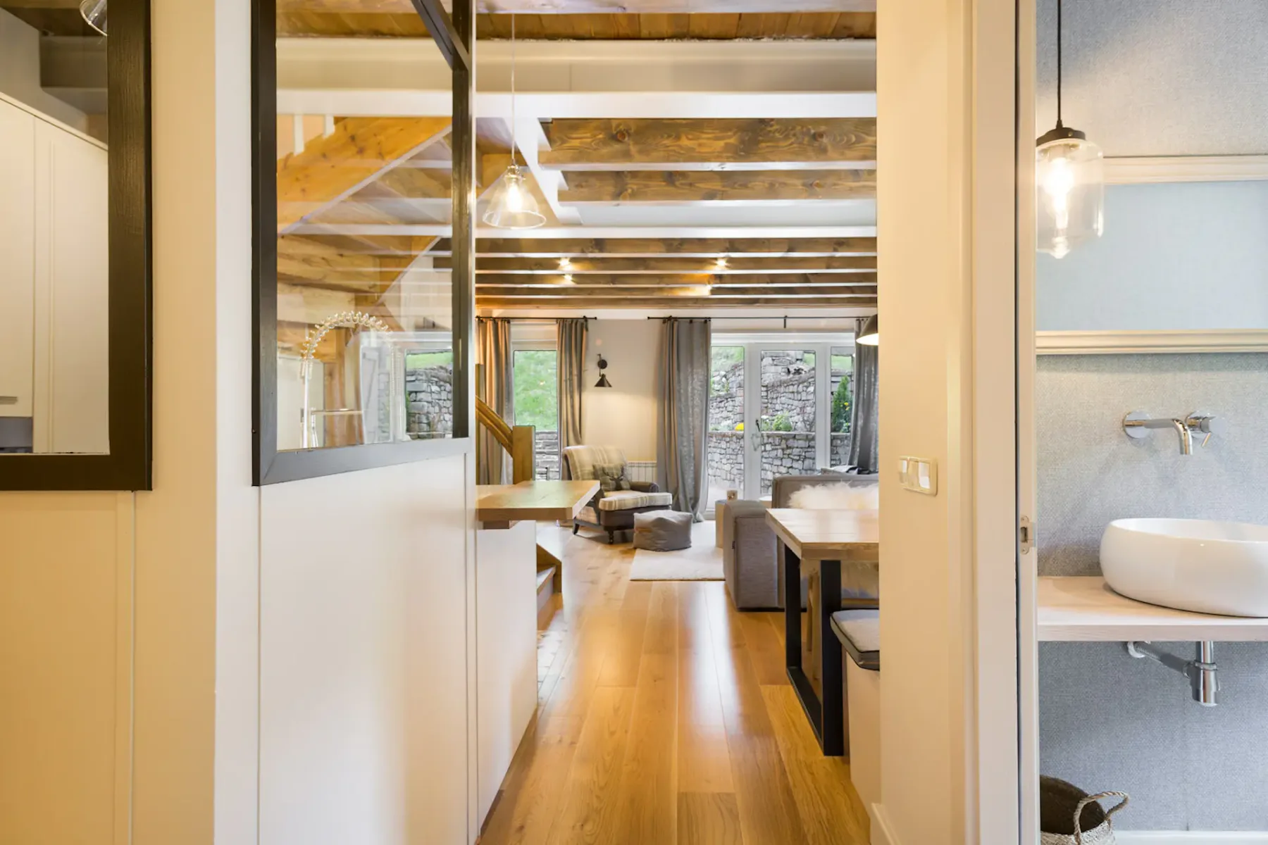 A hallway opens onto a living and dining area, with a bathroom vanity visible at the side.