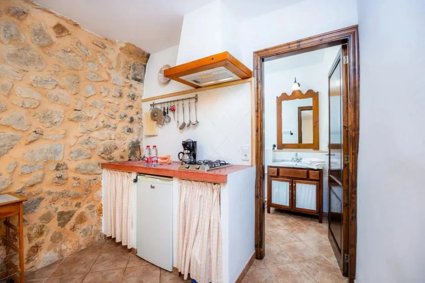 A compact kitchen area opens into a bathroom with a sink and mirror.