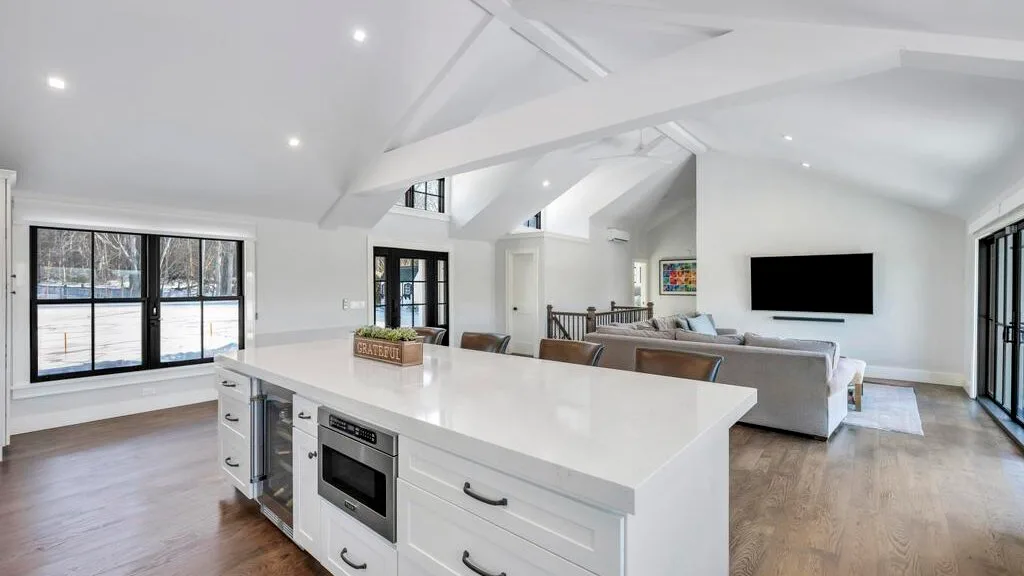 Una cocina luminosa integrada con la sala de estar, una isla grande y asientos.