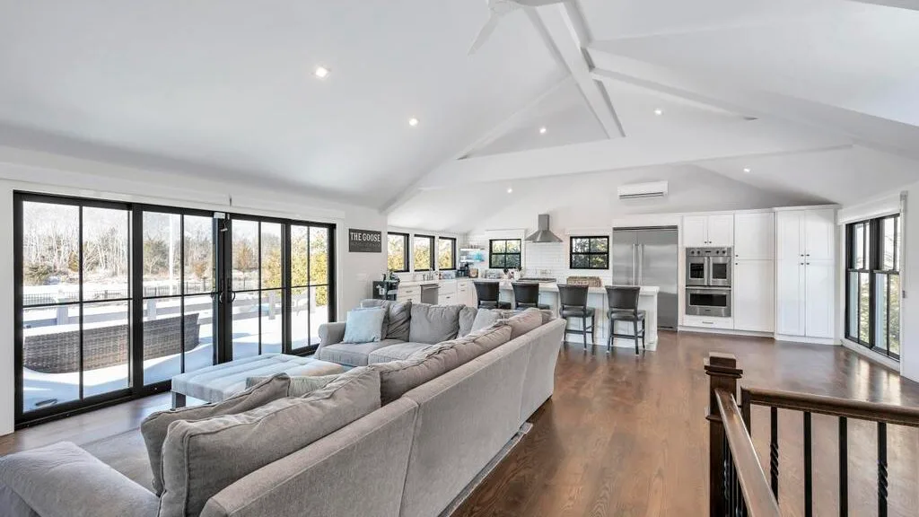 A bright open-plan living and dining area with large windows and a seating arrangement.