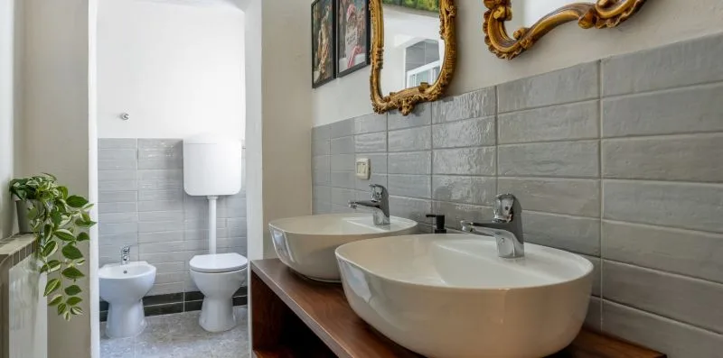 Un baño con dos lavabos sobre encimera y un inodoro.