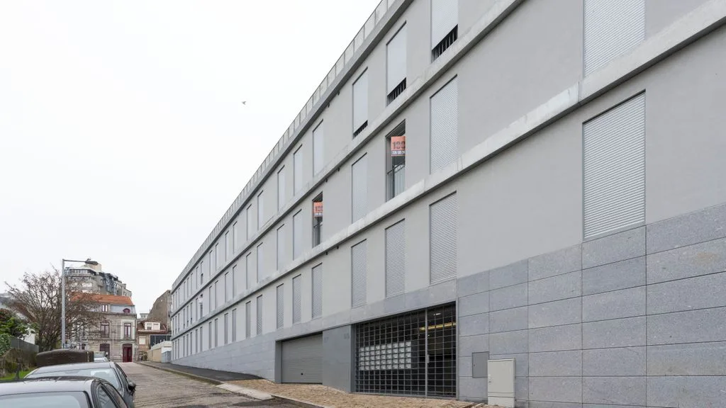 A modern multi-story building with rows of windows along the street.