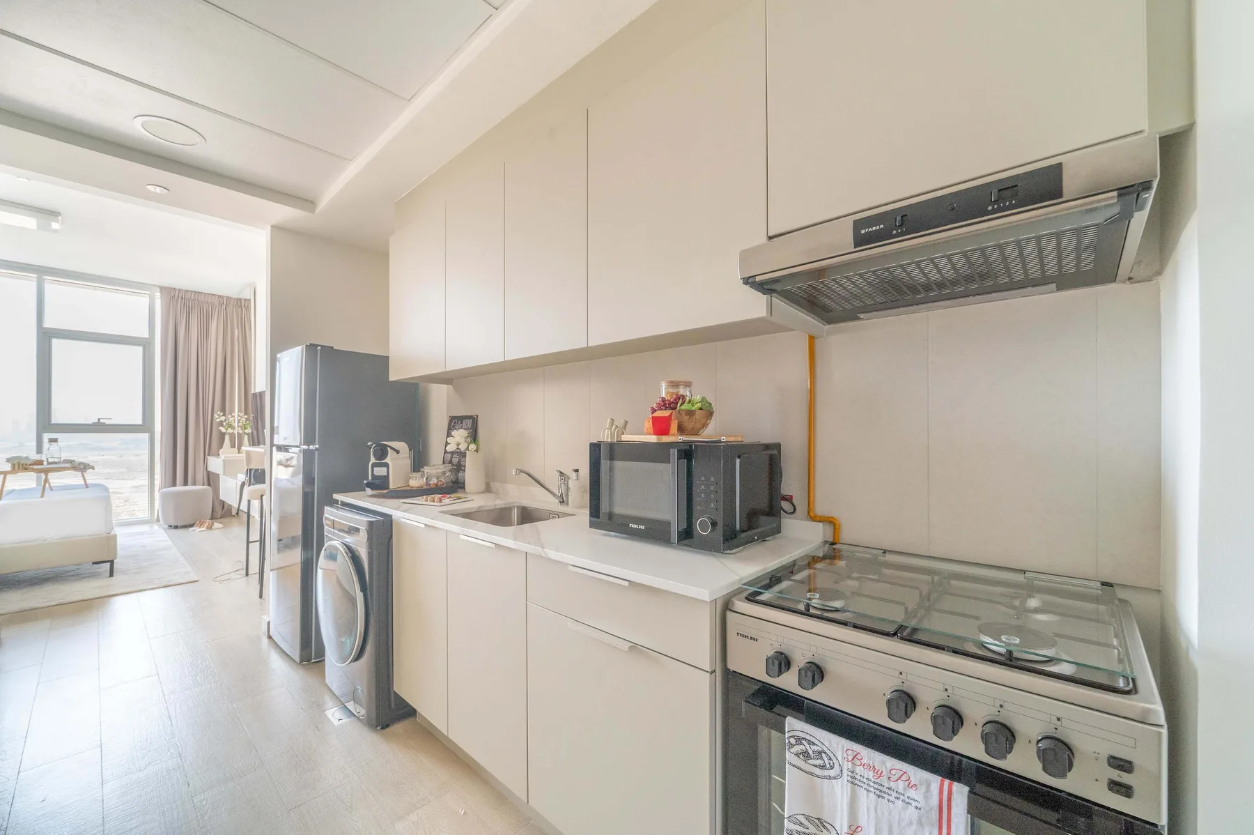 Una cocina luminosa con un microondas sobre la encimera y una estufa.