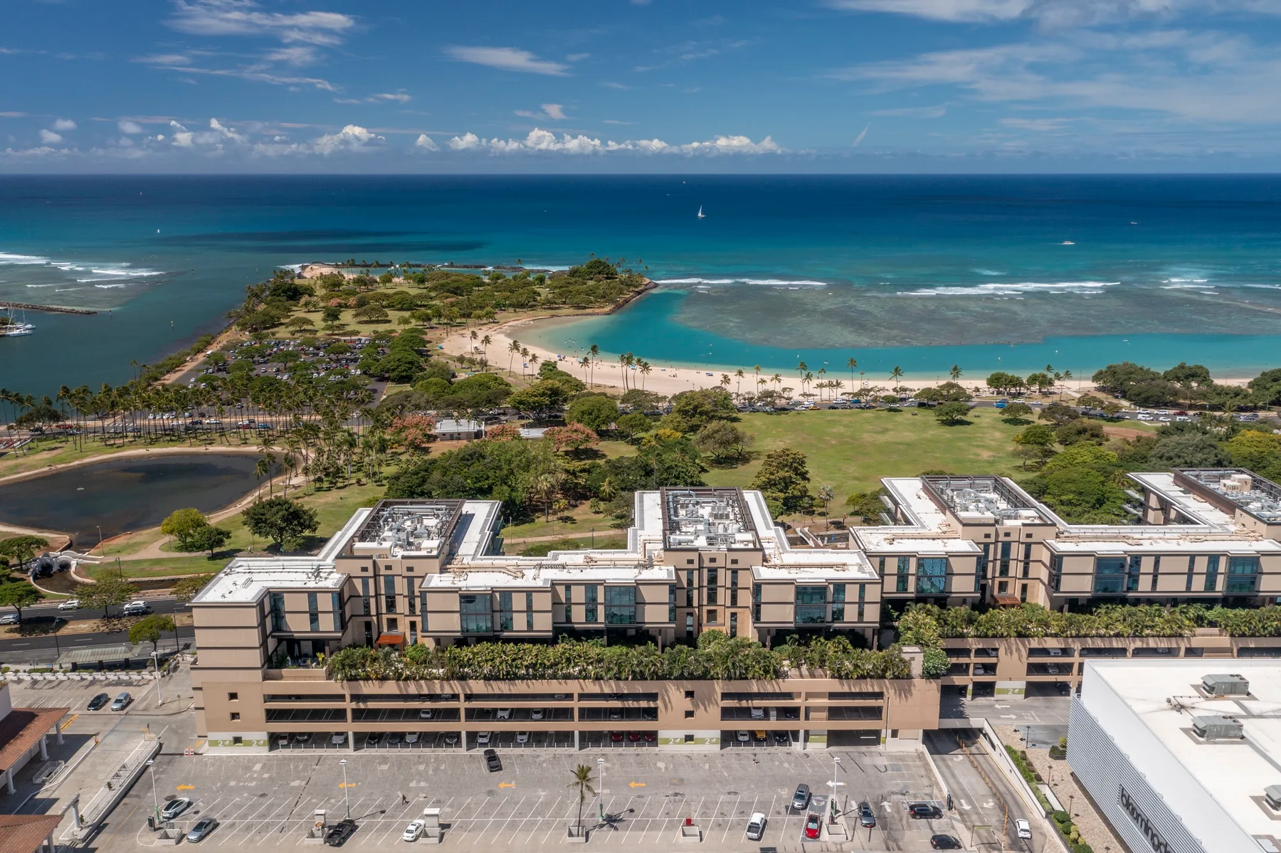 Aerial view of a coastal resort complex beside a curved beach and turquoise water.